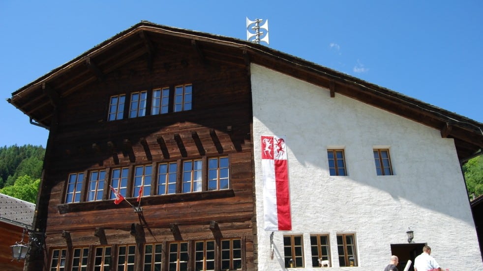 Bâtiment distinctif bois et blanc avec drapeau et girouette.