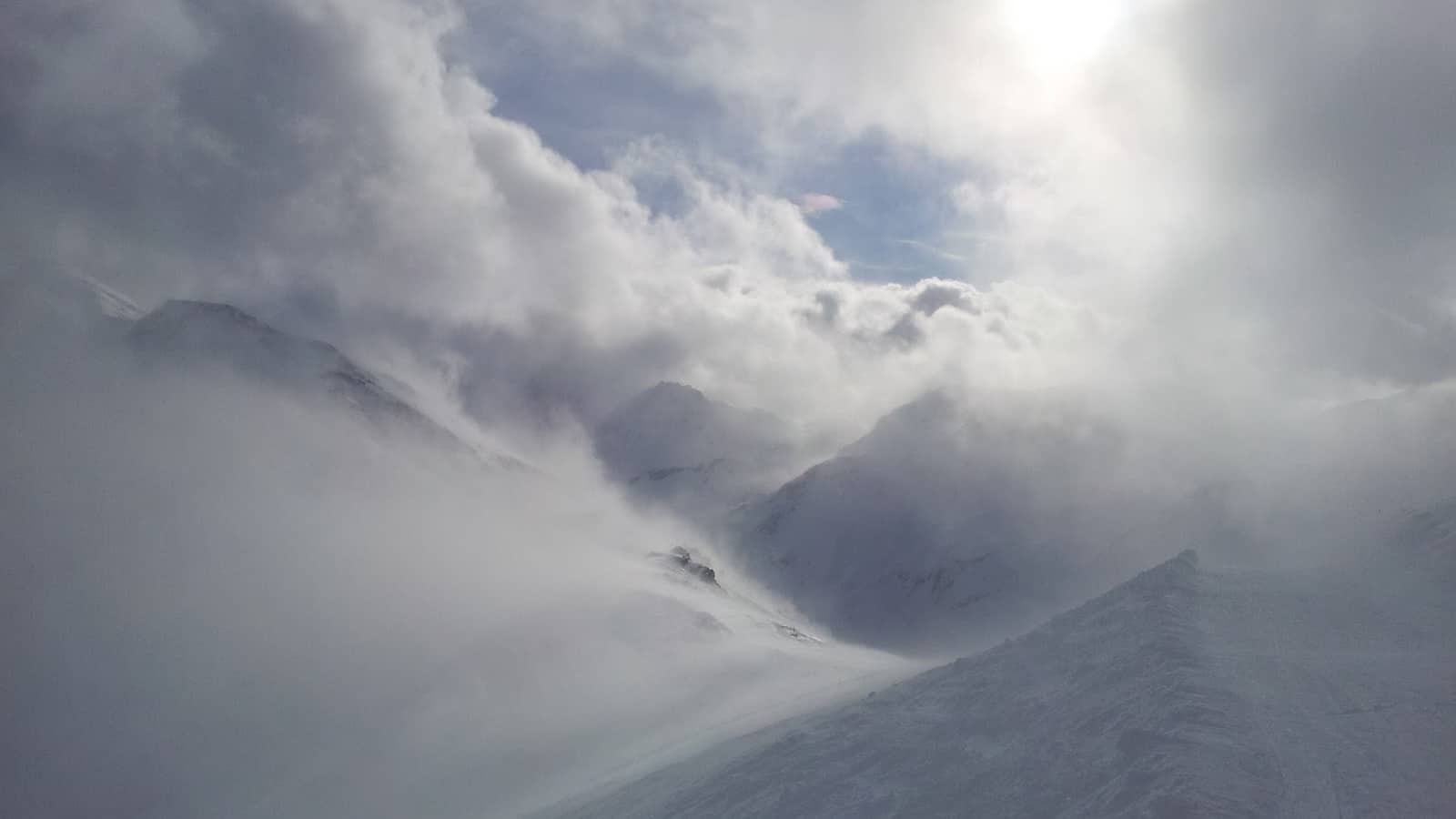 Montagnes enneigées sous un ciel nuageux et brumeux.