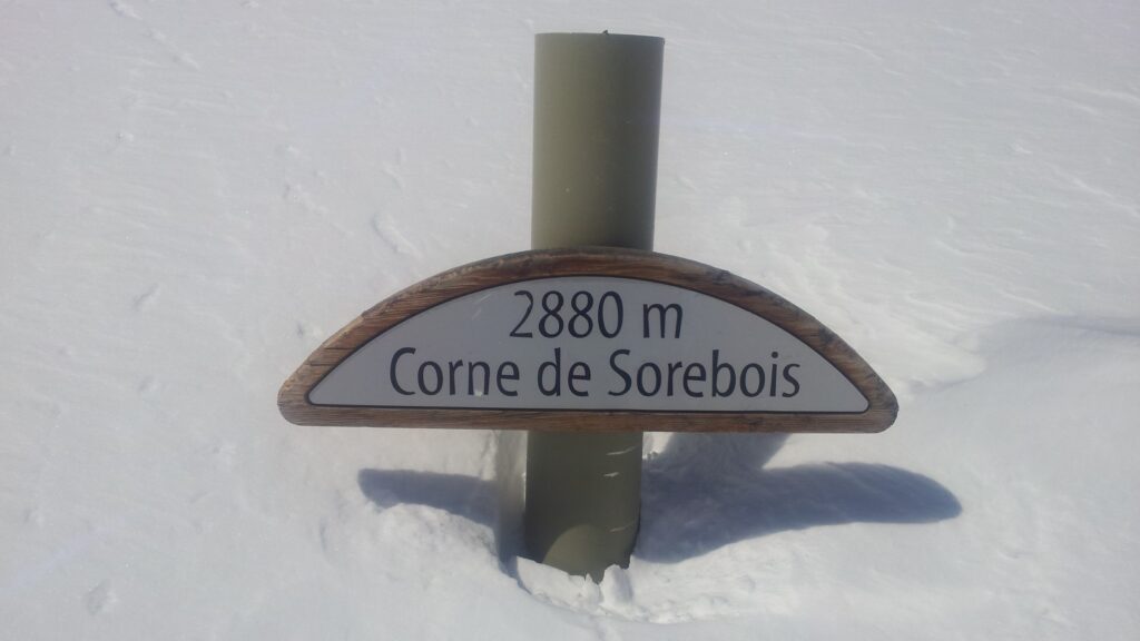 Panneau indiquant l'altitude de 2880 m au sommet de la Corne de Sorebois, entouré de neige.