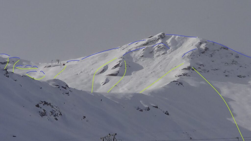 Vue de montagnes enneigées avec des lignes bleues indiquant les cassures et des lignes vertes marquant les bordures d'avalanches.