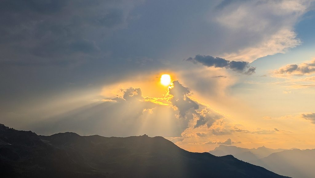 Soleil éclatant à travers les nuages au-dessus des montagnes