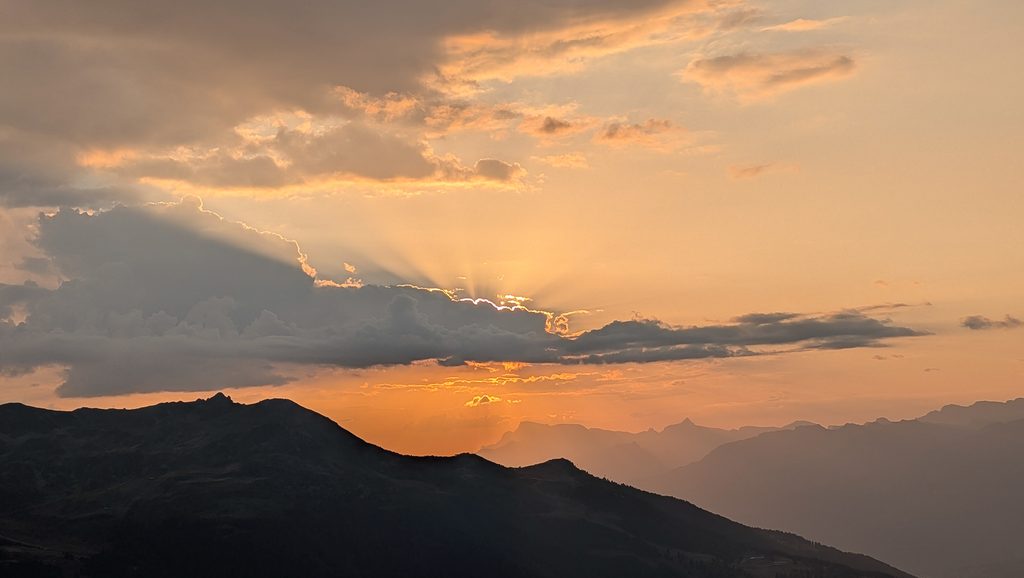 Coucher de soleil sur les montagnes, rayons de lumière à travers les nuages.