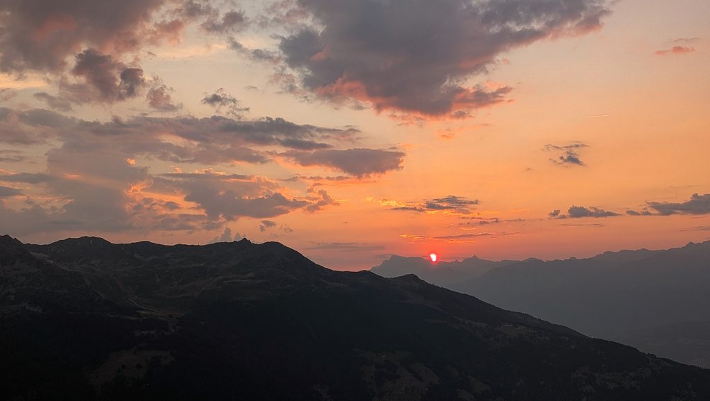 Coucher de soleil orange sur montagnes avec nuages