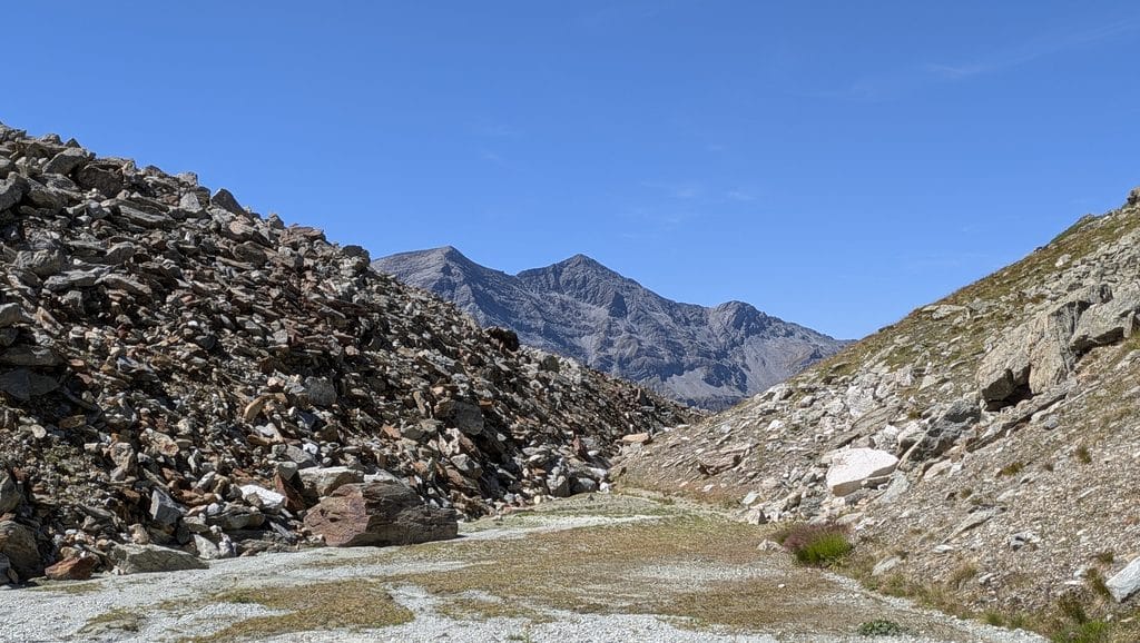 Vallée de montagne rocheuse sous un ciel bleu clair.