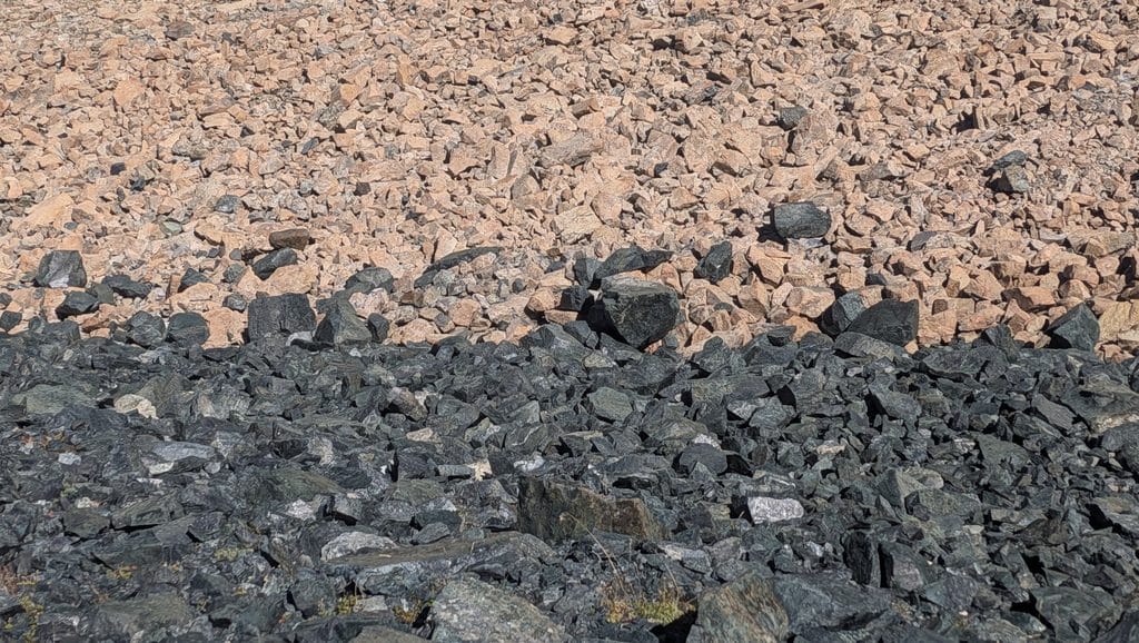 Terrain rocheux bicolore : pierres claires et sombres.