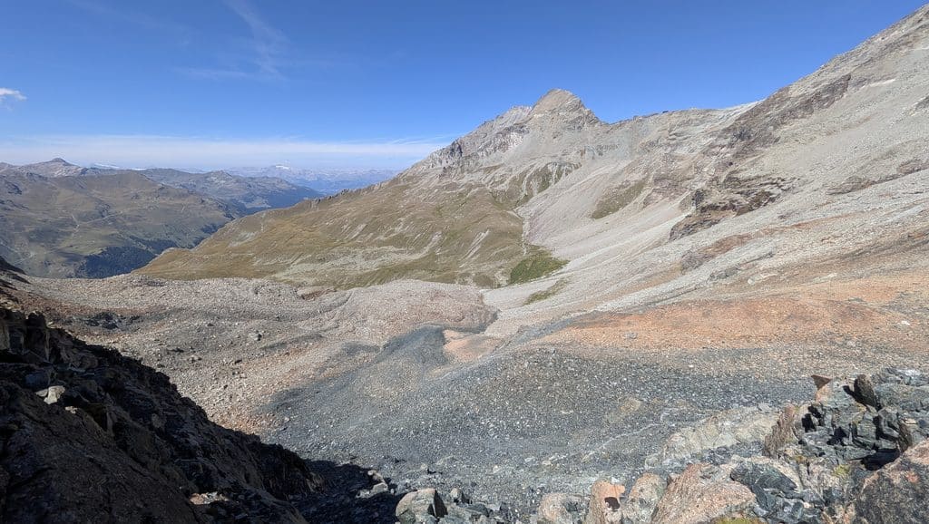 Vaste paysage alpin rocheux sous un ciel bleu lumineux.