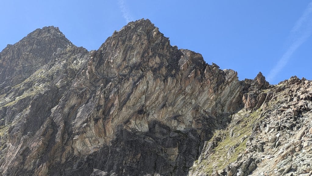 Sommet rocheux et escarpé sous un ciel bleu dégagé.