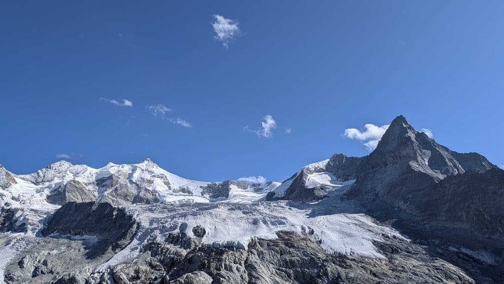 Montagnes enneigées et glaciers sous un ciel bleu éclatant.