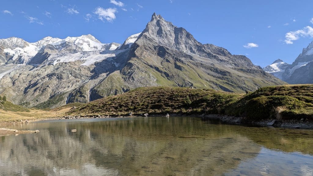 Lac alpin, montagnes enneigées et ciel bleu limpide.